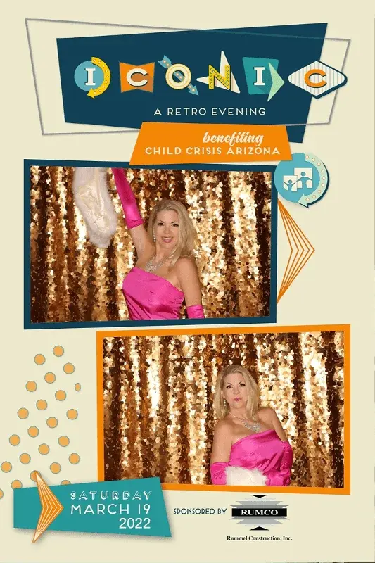 Woman in a pink dress posing at a photo booth during a retro-themed event.